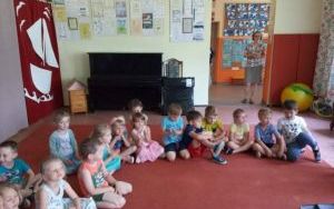 przedszkolaki na dywanie słuchają muzycznej audycji