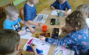 dzieci malują akwarelamii za pomocą palców i pędzelka