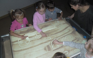 dzieci malują piaskiem