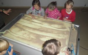dzieci maluja piaskiem leśny krajobraz