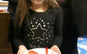 dziewczynka trzyma na talerzu warzywną kanapkę