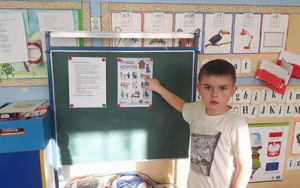 chłopiec wskazuje prawa dzieci na plakacie