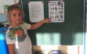 dziewczynka wskazuje jedno z praw dzieci na ilustracji
