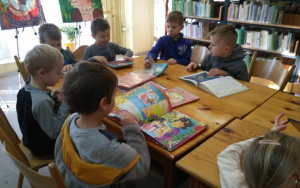 chłopcy oglądają książeczki o tematyce świątecznej