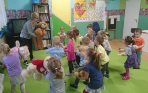 dzieci z nauczycielka śpiewaja piosenke dla misia