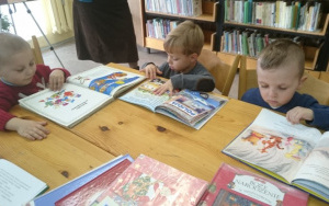 chłopcy oglądają książki o tematyce świątecznej