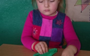 Dziewczynka składa choinkę z papierowej serwetki