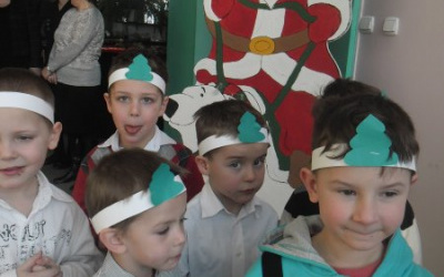 Chłopcy w opaskach na głowie pod planszą z Mikołajem